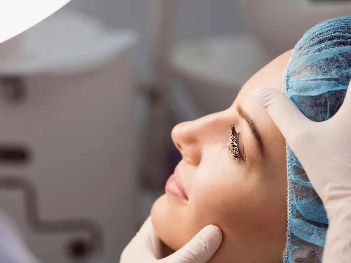 Valoración de rinoplastia en Bogotá: el cirujano examina la nariz de la paciente
